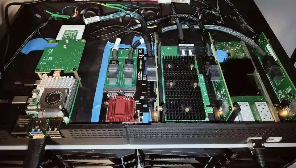 An overhead view of a custom-built computer case interior filled with green circuit boards, cooling fans, and various…