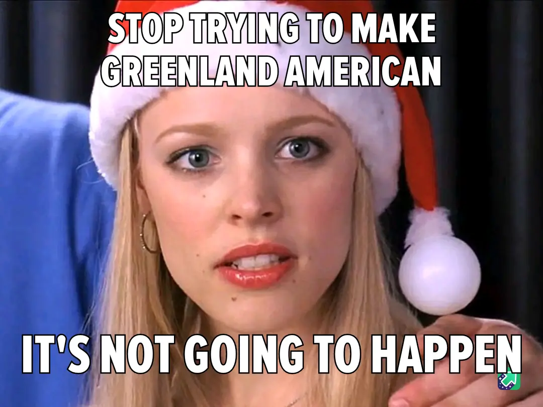 A woman with blonde hair and blue eyes wears a red and white Santa hat while holding a white ornament. She has a stern…