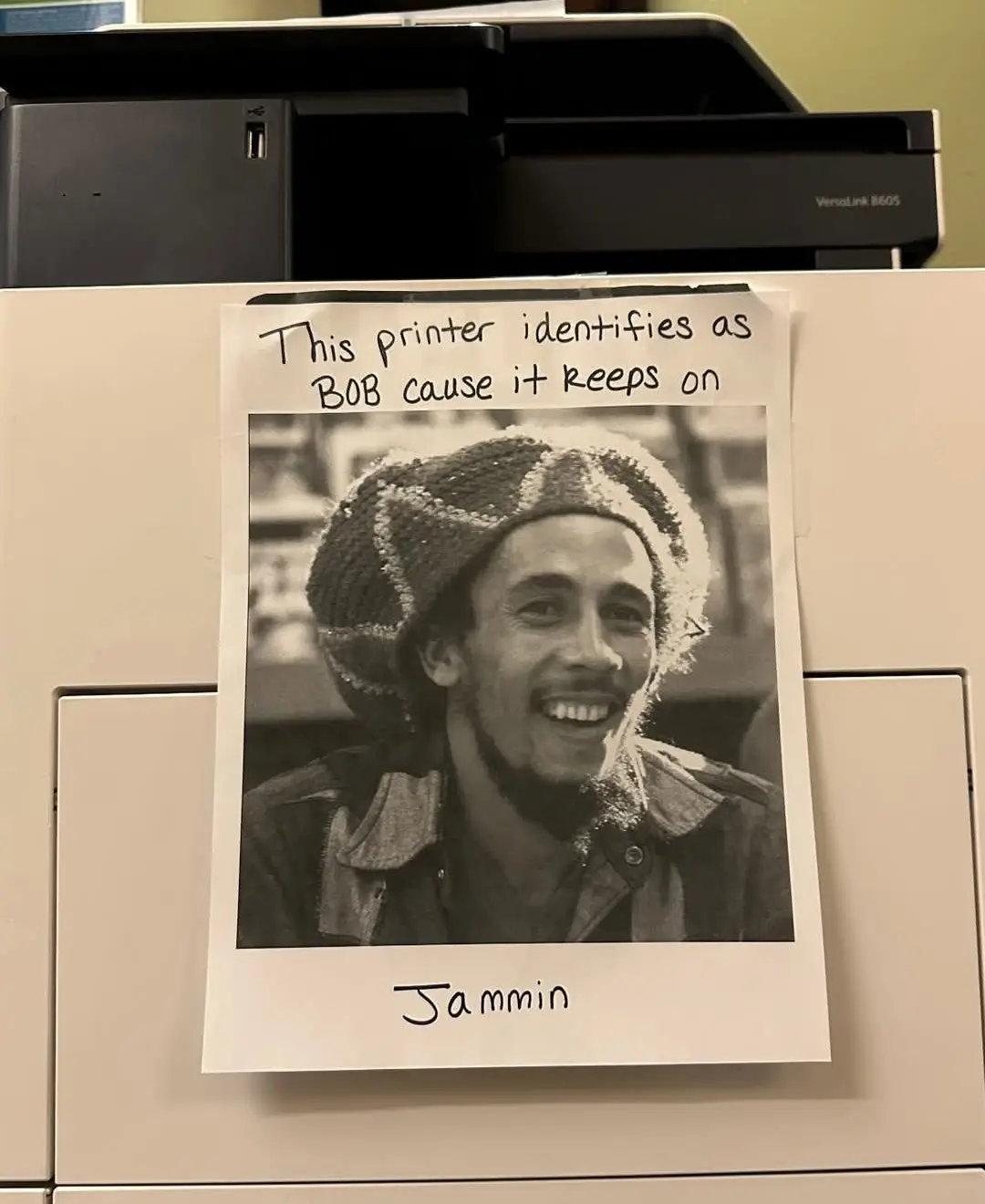 A handwritten note on a printer reads 'This printer identifies as BOB cause it keeps on' above a black and white photo of…