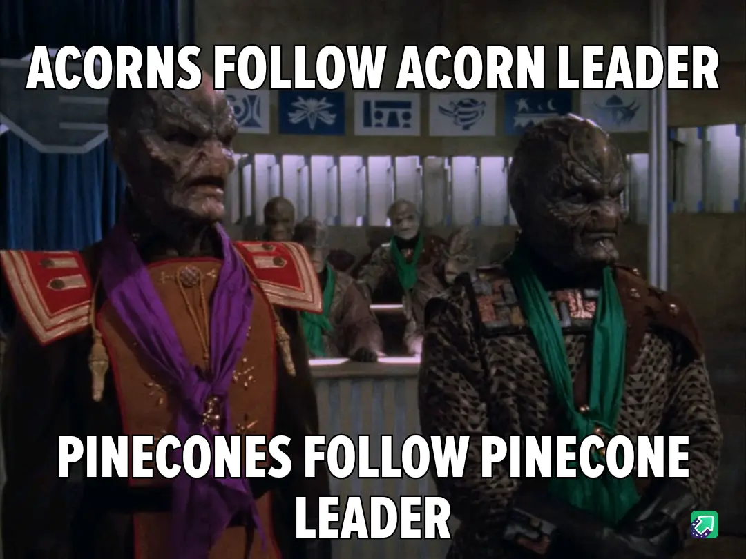 Two Klingon-like alien characters in ornate uniforms stand side by side in a formal setting, with overlaid text reading…
