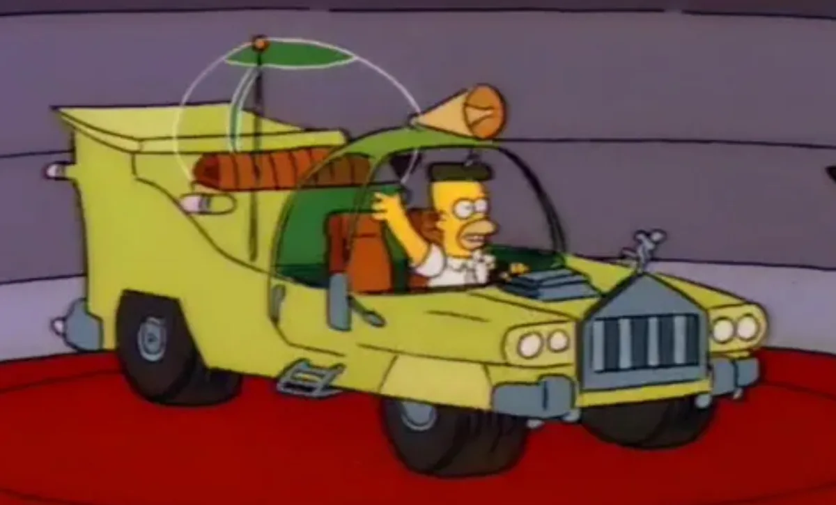 homer simpson is driving a yellow, modified car with a horn on top and a parasol attached to the roof, waving his hand while…