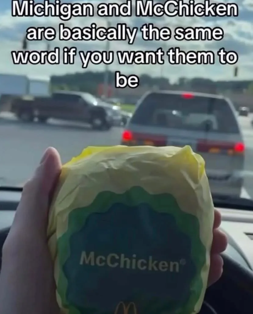 A hand holds a wrapped McDonald's McChicken sandwich inside a car, with traffic visible through the windshield. The overlaid…