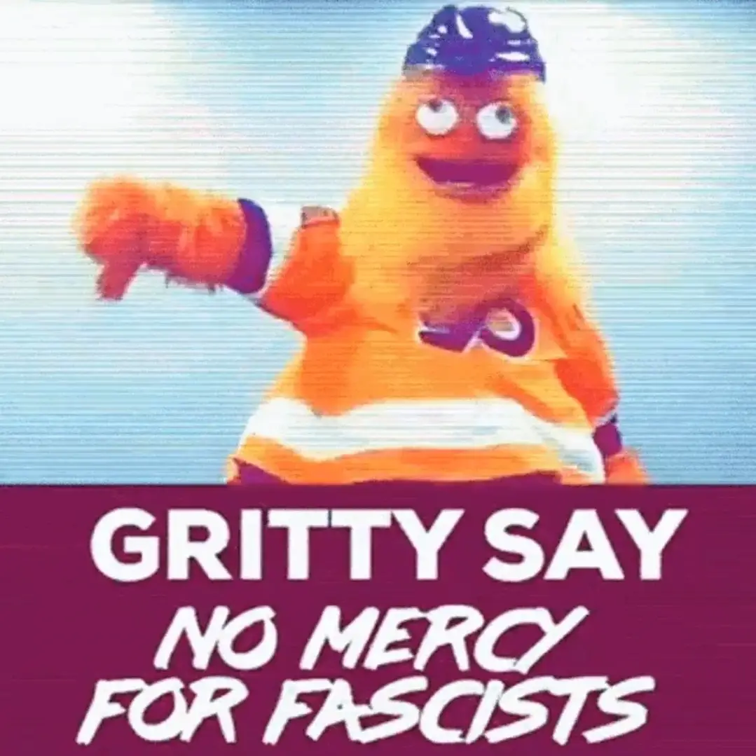 The image shows Gritty, the orange, furry mascot of the Philadelphia Flyers hockey team, wearing a hockey helmet and jersey…