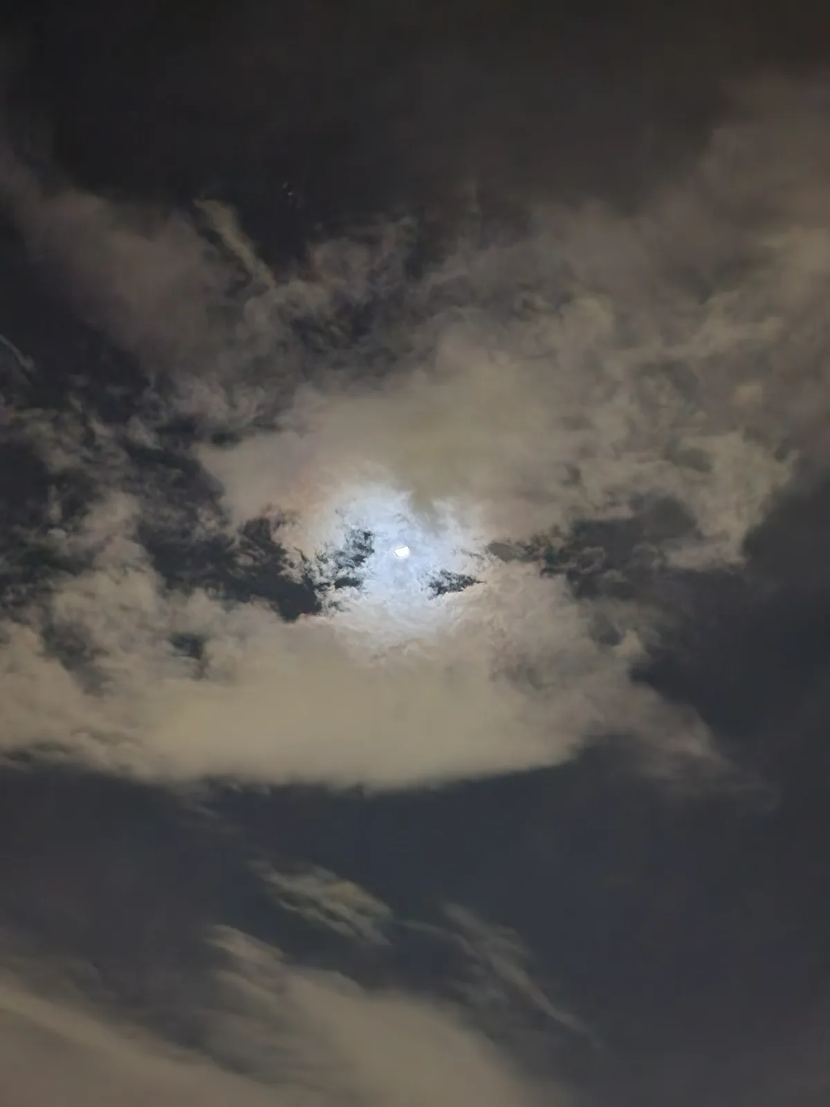 A night sky with dark and light clouds, a bright moon visible through a break in the clouds, overlaid with the text 'i'm not…