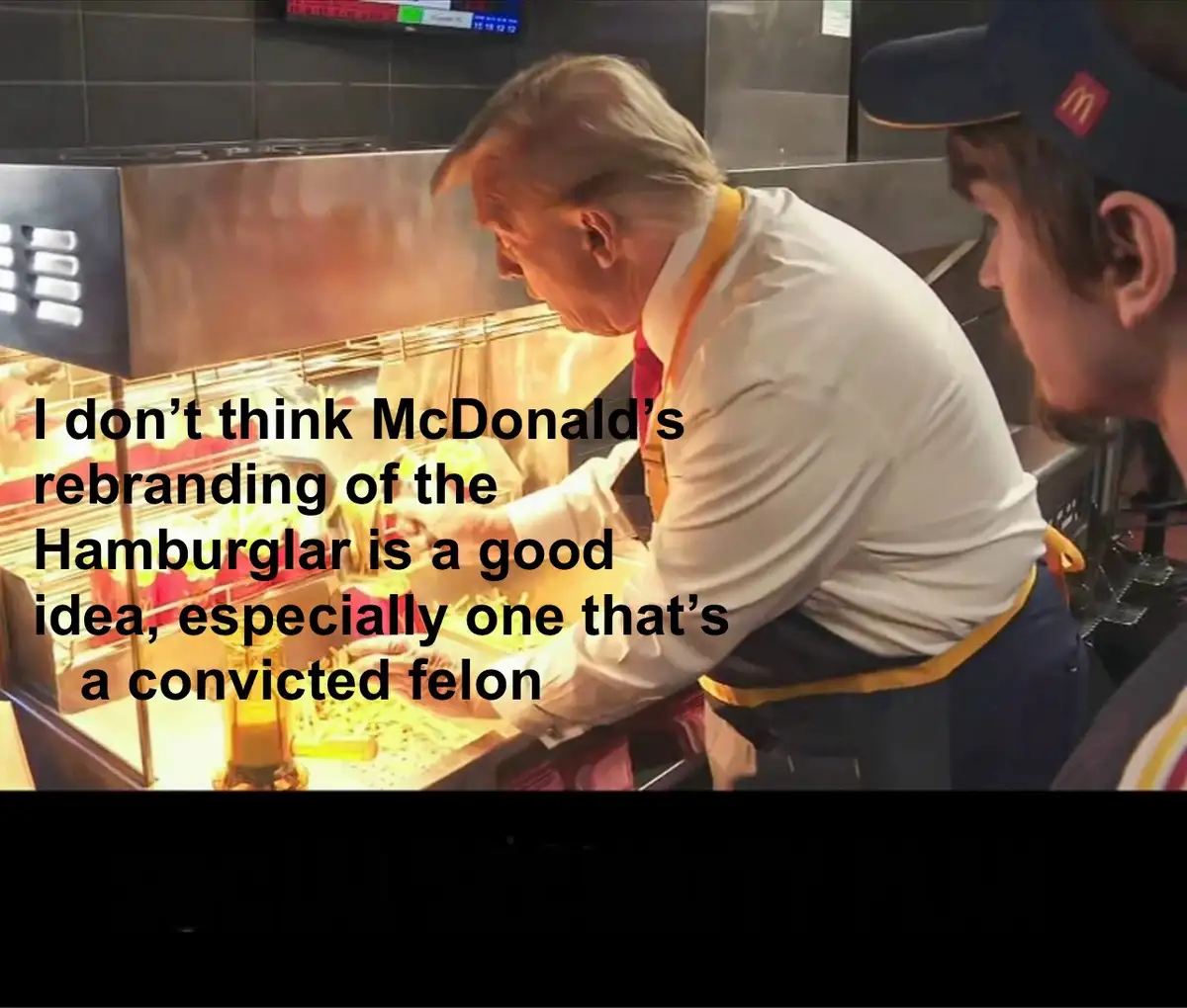 A man in a McDonald's uniform, resembling Donald Trump, is shown working behind the counter in a fast-food kitchen. Another…