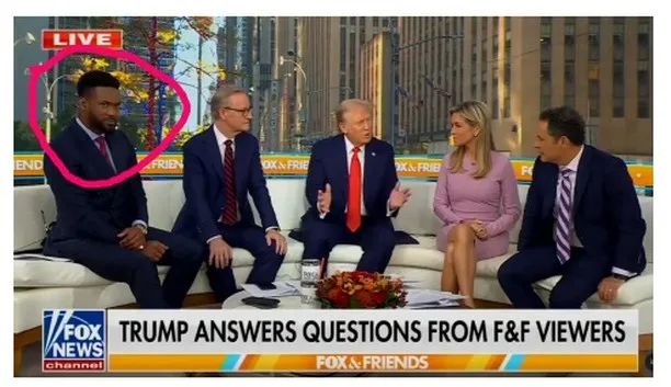 A still from a Fox News 'Fox & Friends' live broadcast shows five hosts seated on a white couch. A pink circle highlights…