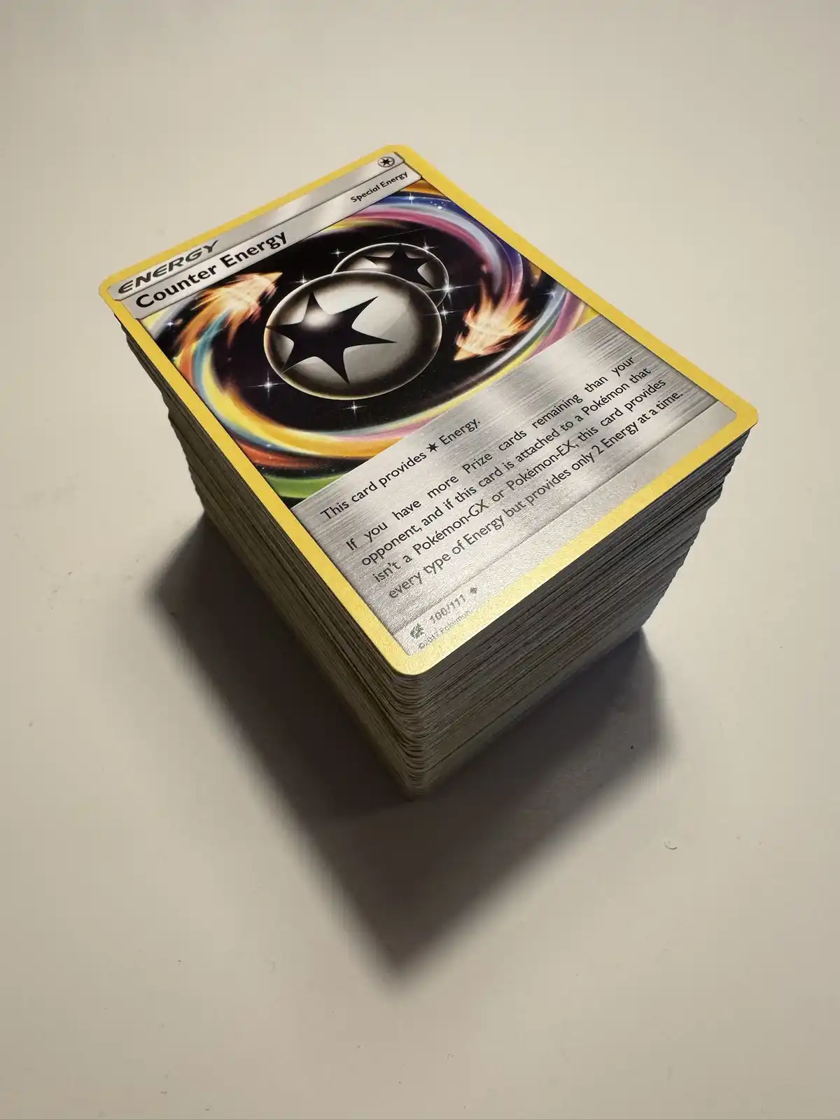 A stack of Pokémon trading cards, with the top card being 'Counter Energy', a Special Energy card with a star motif and…