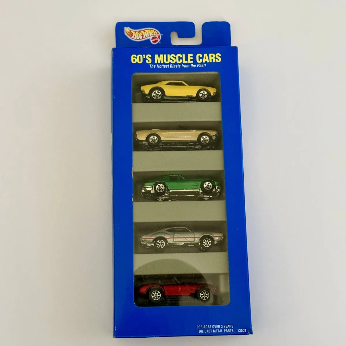 A blue Hot Wheels toy car package displays five miniature 1960s muscle cars stacked vertically in clear plastic…