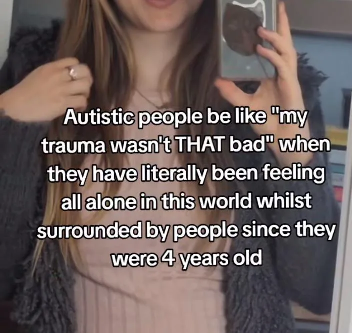 A person with long hair holds up a phone displaying a dark, textured object while looking at their reflection. White text…