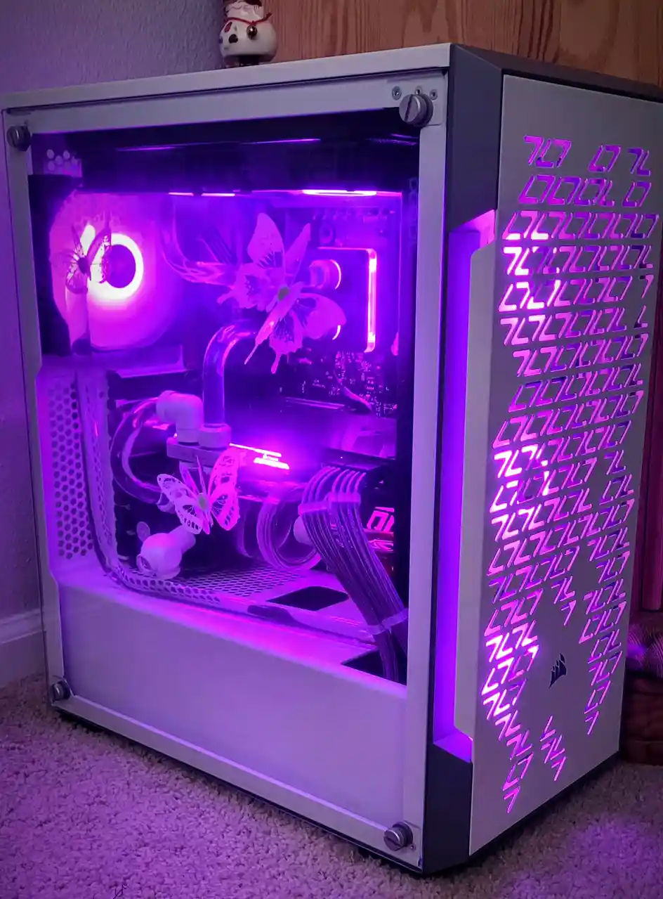 A custom-built PC case with a transparent side panel, illuminated by purple LED lighting, revealing internal components…