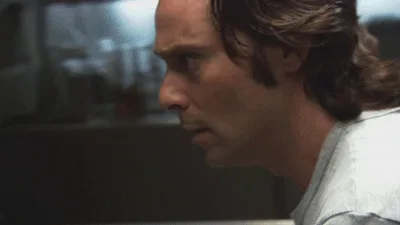 A six-panel image sequence shows a man in a grey t-shirt reacting with increasing shock and disbelief while typing on a…