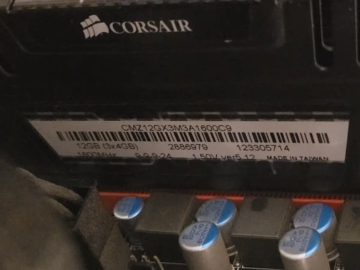A close-up photo of a Corsair RAM stick's label, showing its model number CMZ12GX3M3A1600C9, capacity 12GB (3x4GB), speed…
