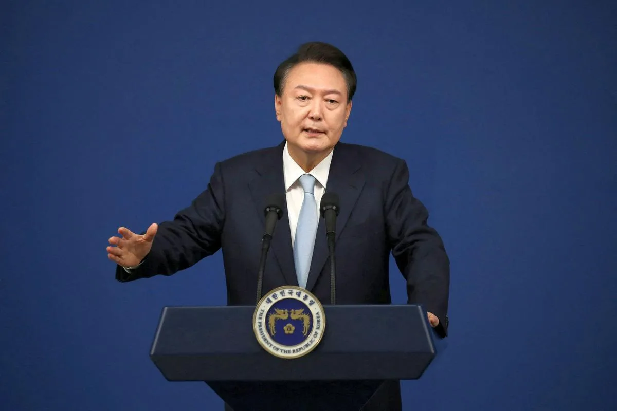 a man in a dark suit and light blue tie stands at a dark blue podium with two microphones and a presidential seal, gesturing…