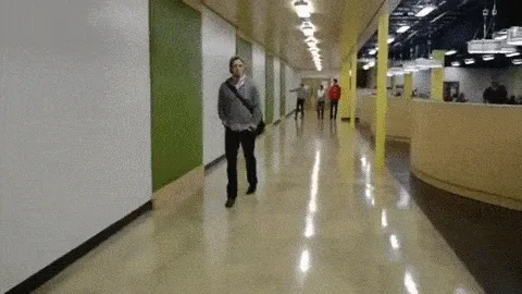 A six-panel sequence shows a man in a grey hoodie walking down a brightly lit office hallway, then suddenly being attacked…