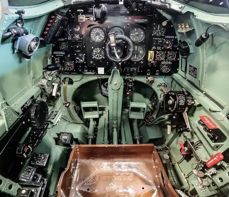a close-up photo of an old military aircraft cockpit filled with numerous dials, gauges, levers, and switches, all set…