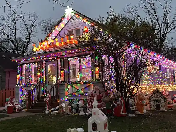 a house is covered in an overwhelming amount of colorful christmas lights and decorations, including reindeer, santa claus…