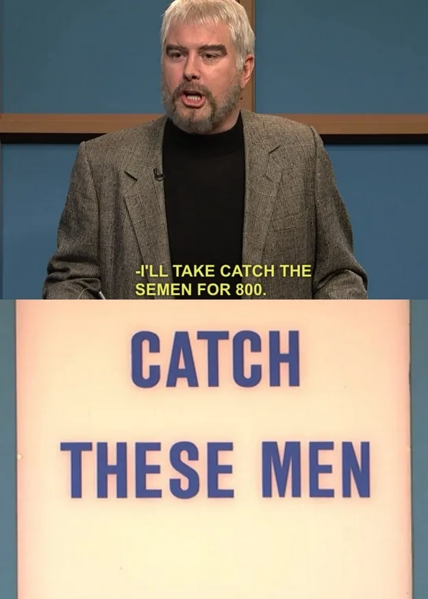 A man with gray hair and a beard, wearing a gray blazer over a black turtleneck, is shown on a game show set. He is speaking…