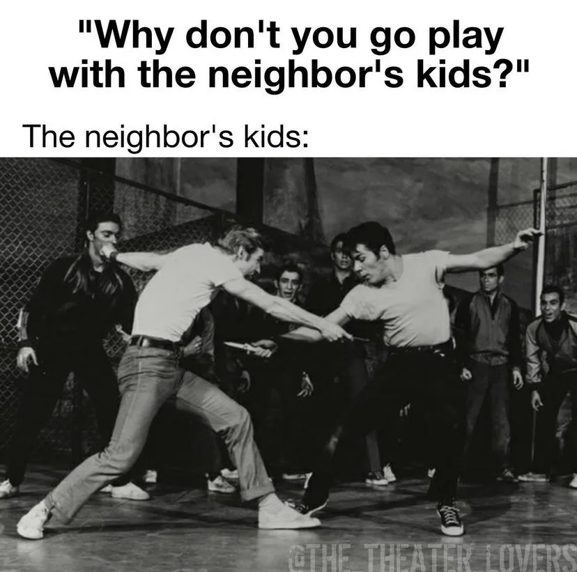 A black-and-white photo shows two young men in a tense, physical confrontation, each holding a knife, while several other…