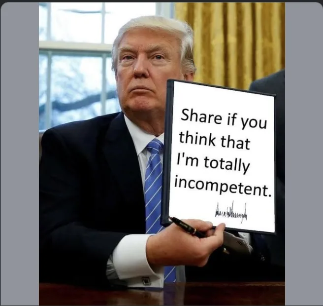 A man in a dark suit and blue striped tie sits at a desk holding a whiteboard with black text that reads 'Share if you think…