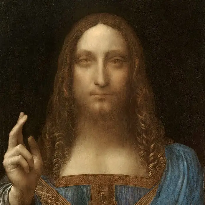 A close-up of Leonardo da Vinci's painting 'Salvator Mundi' shows a figure with long brown hair and a beard, wearing a blue…