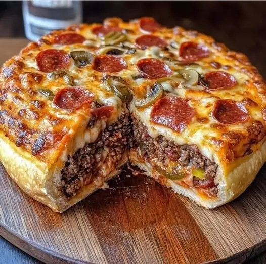 a close-up photo of a round, cheesy pizza with pepperoni and green peppers on top, sitting on a wooden board. A slice has…