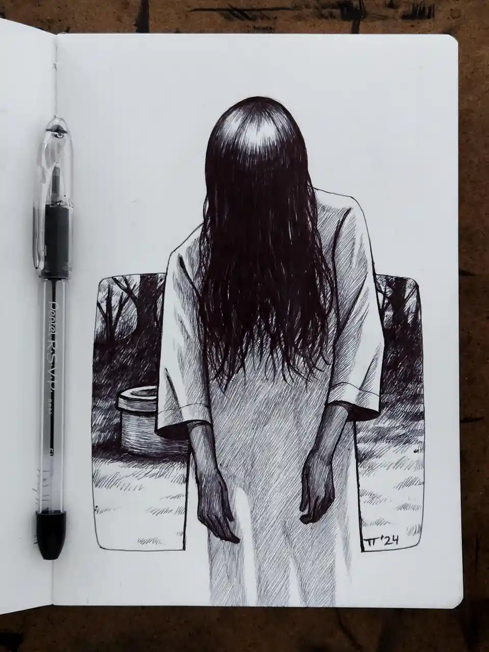 A black-and-white ink sketch in a notebook shows the back of a person with long dark hair, wearing a loose white robe…
