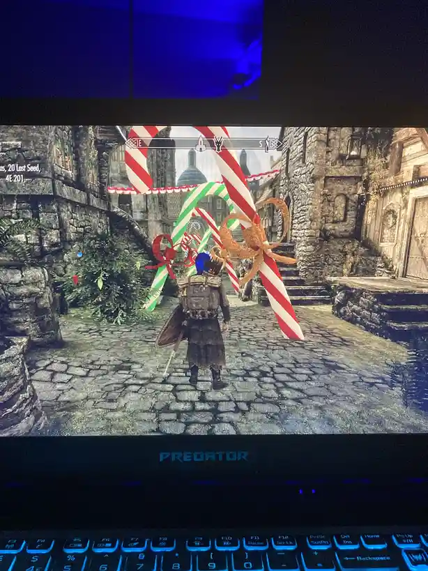 A screenshot from the game Skyrim shows a character walking down a cobblestone street decorated with giant candy canes and…