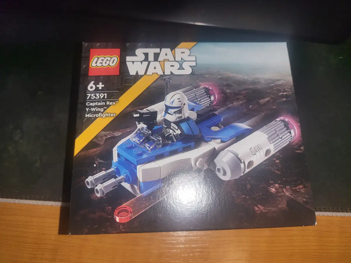 A close-up photo of a LEGO Star Wars set box (set #75391) featuring Captain Rex in a blue and white Y-Wing Microfighter…