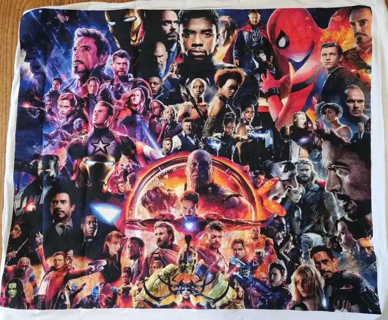 A square, white towel printed with a dense collage of Marvel superhero characters from the 'Avengers: Endgame' movie poster…