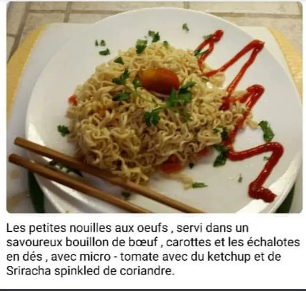 A plate of plain instant noodles garnished with parsley, a cherry tomato, and a zigzag of ketchup, with chopsticks resting…