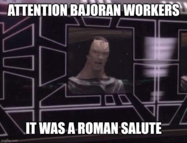 A screenshot from Star Trek: Deep Space Nine shows a Bajoran man in a uniform looking surprised, framed within a futuristic…