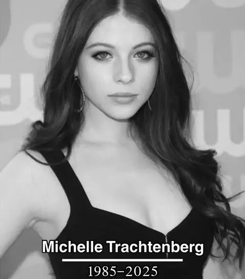 A black-and-white photo of actress Michelle Trachtenberg, looking directly at the camera with a neutral expression, wearing…