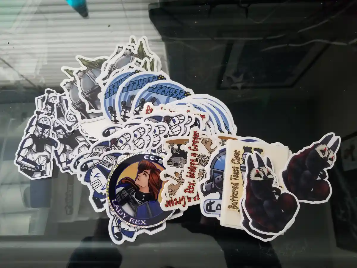 A pile of Star Wars-themed stickers, including Clone Troopers, Yoda, and a 'Lady Rex' sticker with a female character, are…