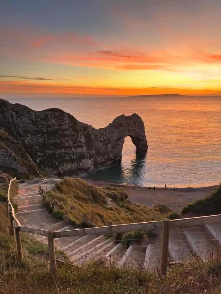 A scenic photograph of Durdle Door, a famous natural limestone arch on the Jurassic Coast in Dorset, England, captured…