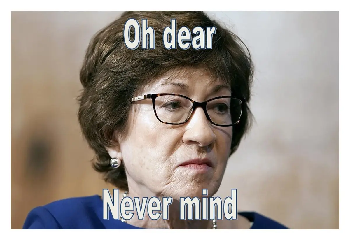 A close-up photo of an older woman with short brown hair, glasses, and a pearl earring, wearing a blue top. She has a…