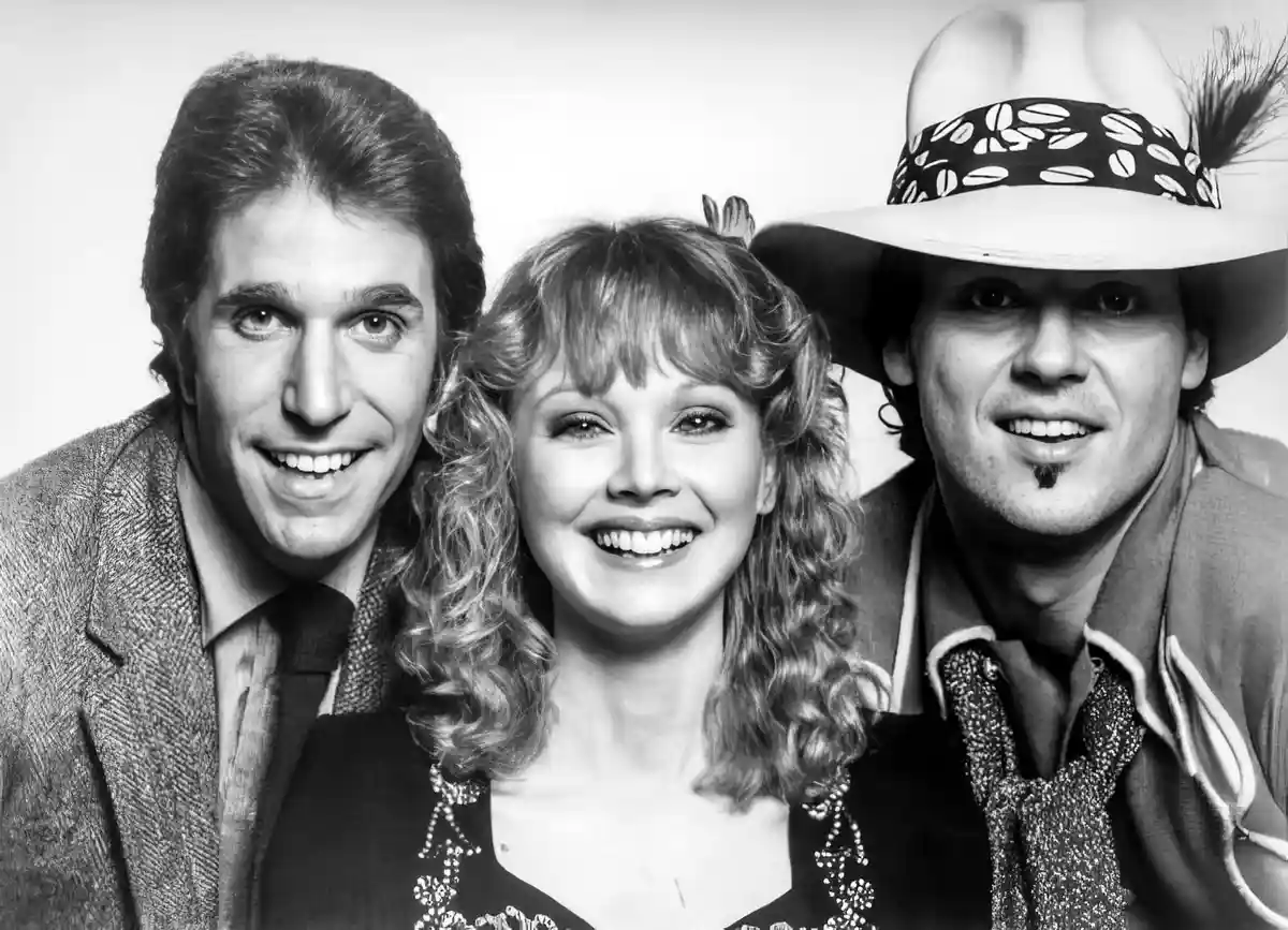 A black-and-white promotional photo of the 1980s TV show 'Dallas' featuring actors Patrick Duffy, Linda Gray, and Charlene…