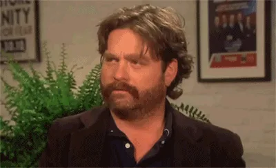 A six-panel image shows actor Zach Galifianakis in a dark blazer and blue shirt, seated in front of a green fern and framed…