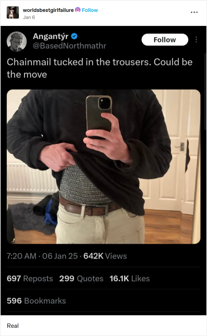 A person takes a mirror selfie while tucking a chainmail shirt into their light-colored trousers, revealing the metallic…