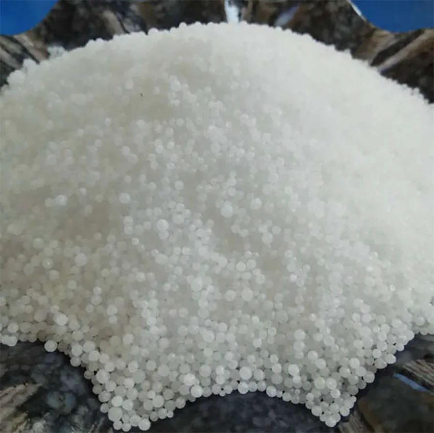 A close-up photo shows a mound of small, white, spherical granules resembling sugar or a similar substance, resting on a…