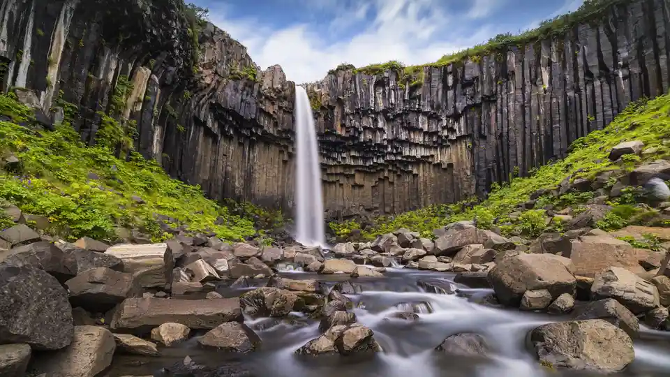 Svartifoss, an Icelandic waterfall, features unique hexagonal basalt columns, shaped by the cooling and contraction of lava…