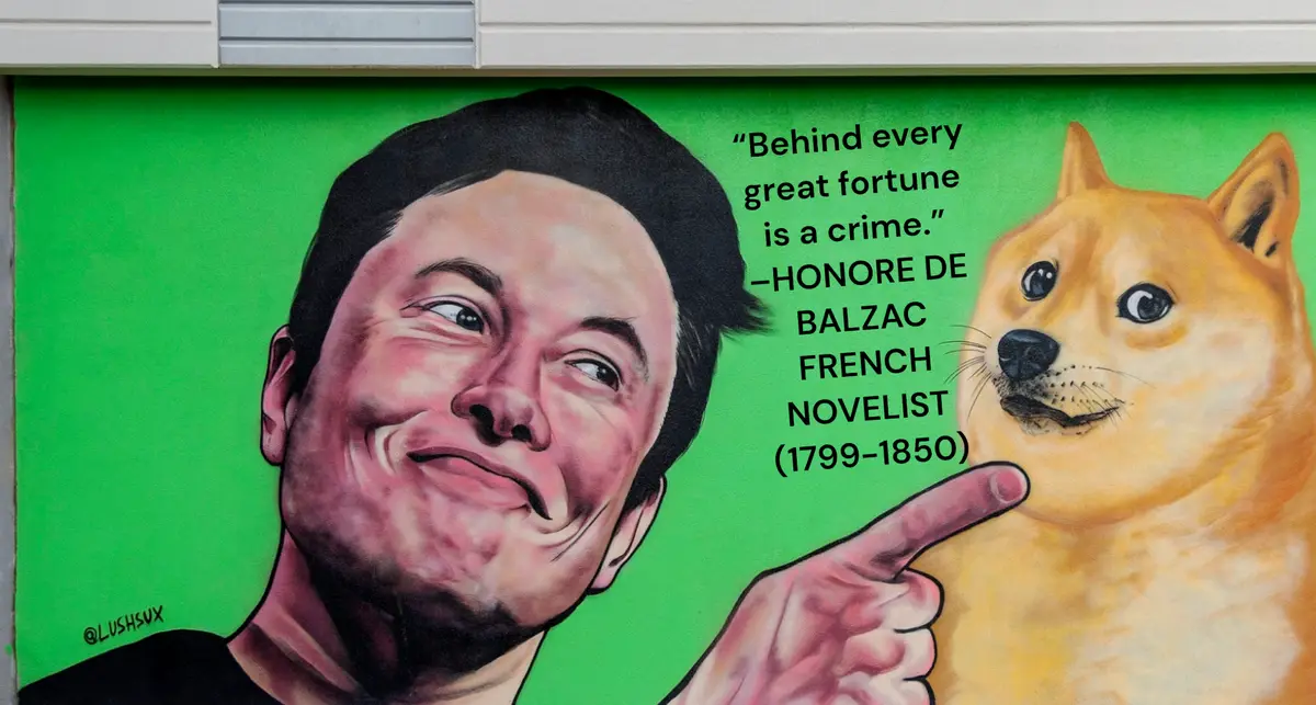 A mural depicts Elon Musk smiling and pointing at a Doge meme dog, with text overlaying the image attributing the quote…