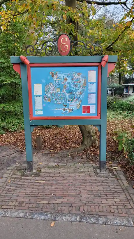 A large, ornate park map kiosk for Efteling amusement park, featuring a detailed illustrated map of the park with…