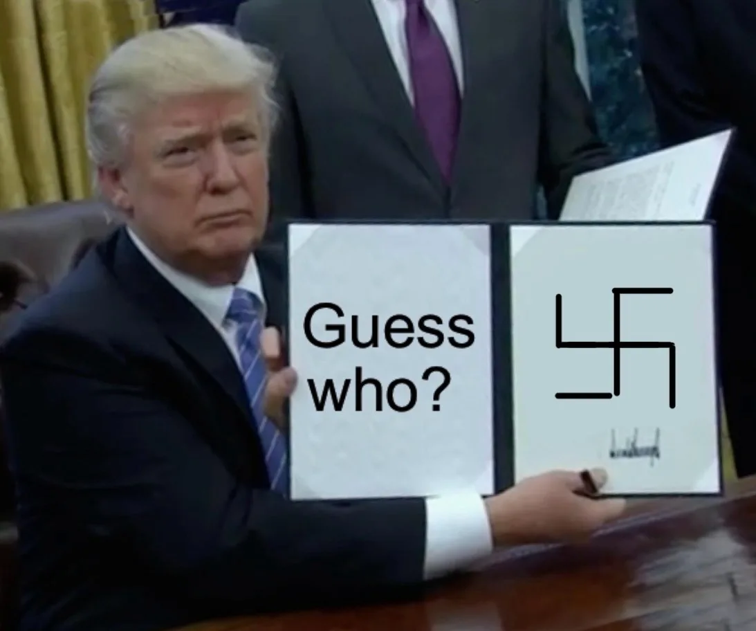 A man in a suit and tie sits at a desk holding an open binder. The left page reads 'Guess who?' and the right page displays…