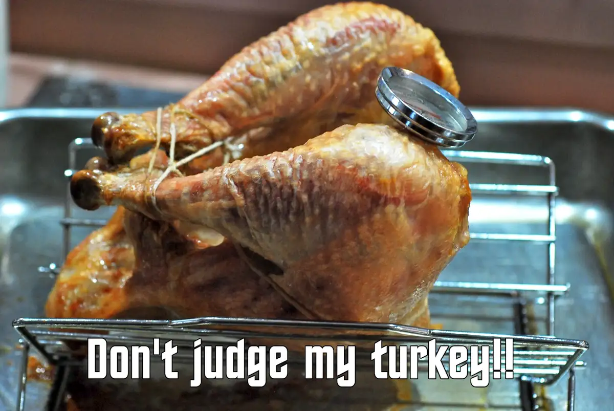 A roasted turkey, likely a whole bird, is shown in a metal roasting pan with a rack. The turkey's skin is golden-brown and…