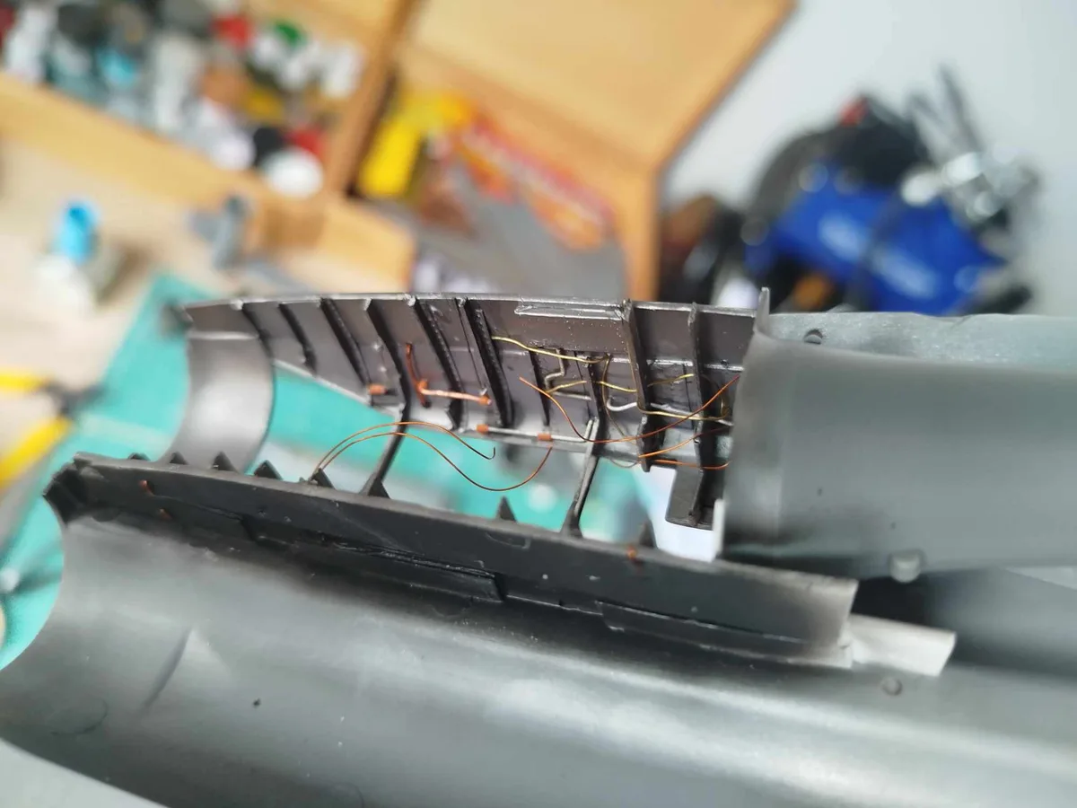 A close-up photo shows the internal wiring of a disassembled keyboard, with copper wires visibly soldered to the circuit…