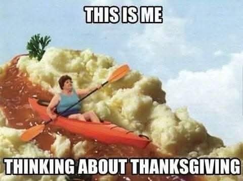 A man in a blue tank top and orange kayak paddles through a giant mound of mashed potatoes with gravy and a parsley garnish…