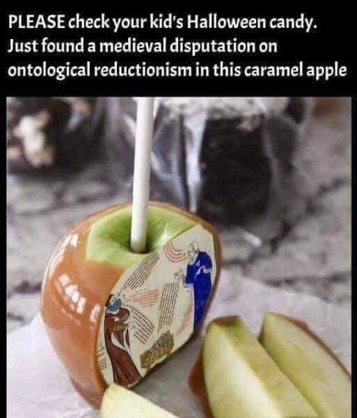 A caramel apple with a white stick is shown, its side decorated with a printed image of two medieval scholars in robes…