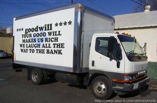 A white delivery truck with a large boxy cargo area has text painted on its side. The text reads: "*** goodwill *** YOUR…