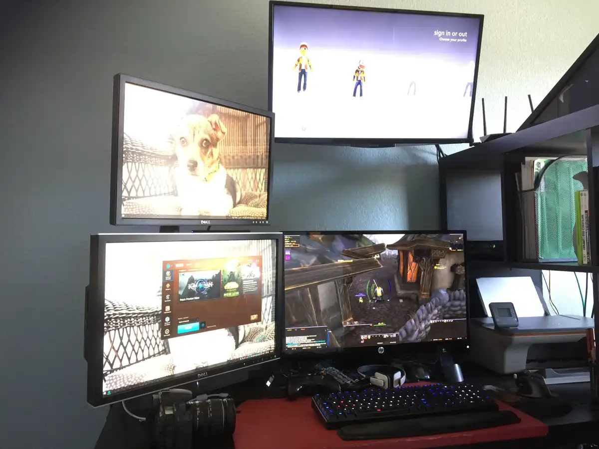 A multi-monitor gaming setup shows four screens: one with a dog, one with a game's sign-in screen, one with a game's main…