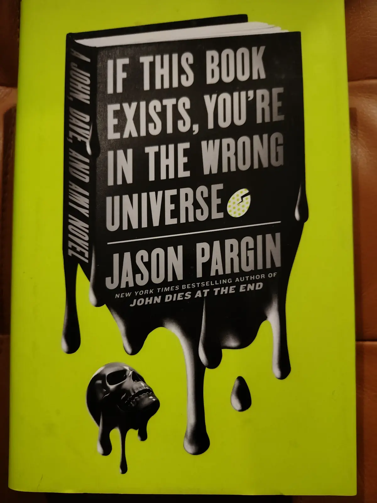 A book cover with a black, melting book shape on a bright lime green background. The title reads 'IF THIS BOOK EXISTS…
